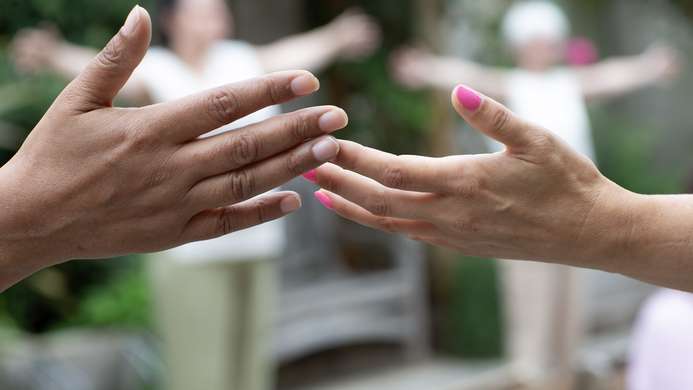 a photo of two hands stretched out, reaching each other