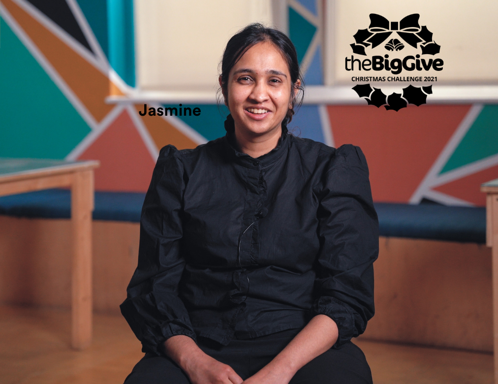 a photo of Jasmine sitting down smiling at the camera, in the Clean Break green room. The Big Give logo is in the top right corner.