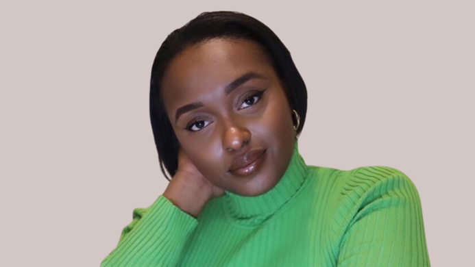 a photo of Yasmin Joseph wearing a green jumper on a beige background