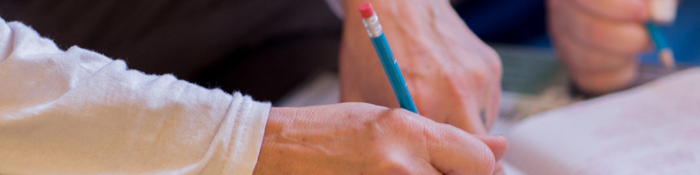 The hands of two people writing together.