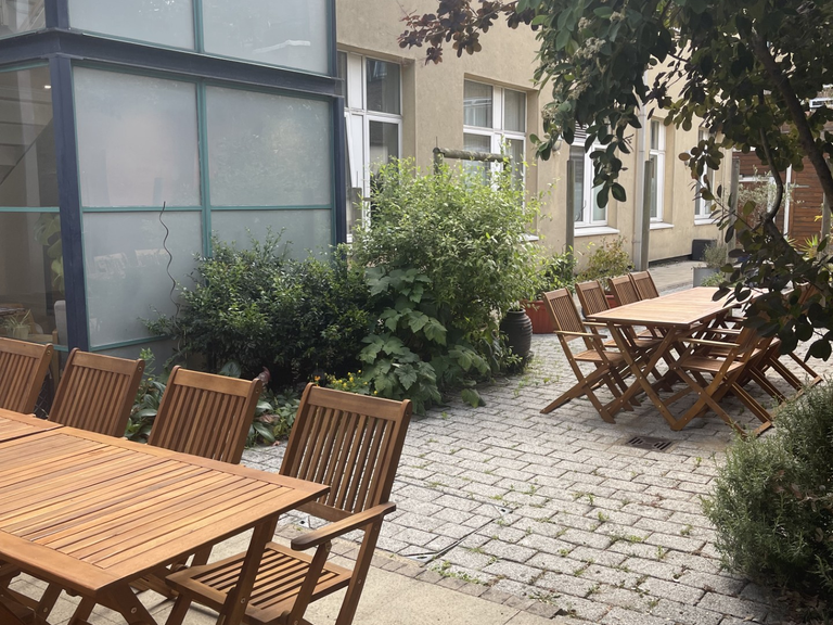 a photo of clean break's courtyard garden with tables and chairs set up