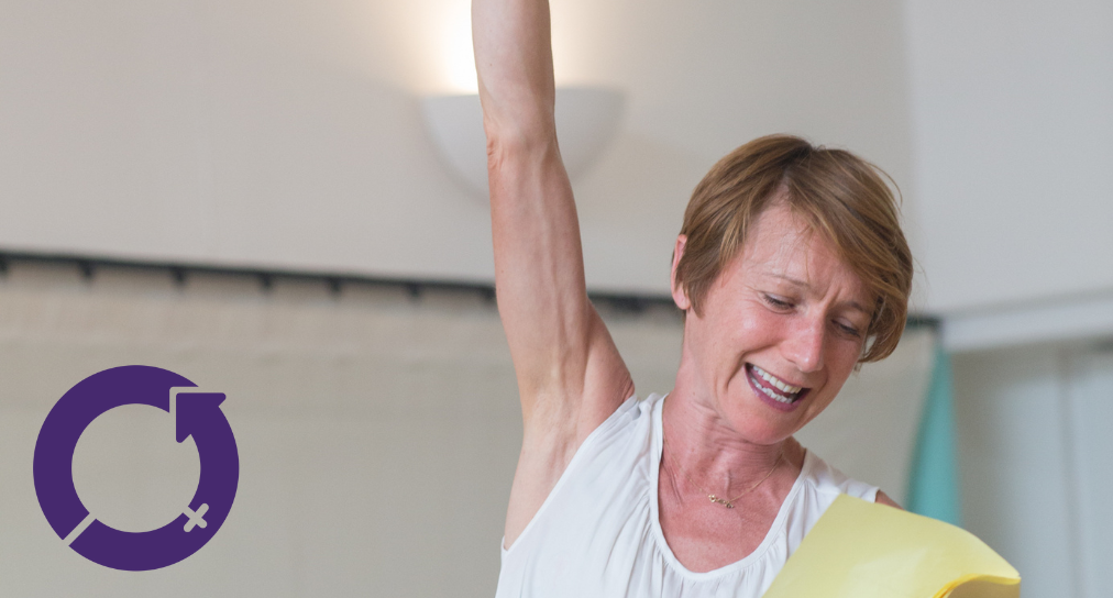 a photo of a woman raising her arm in the air defiantly and reading a script