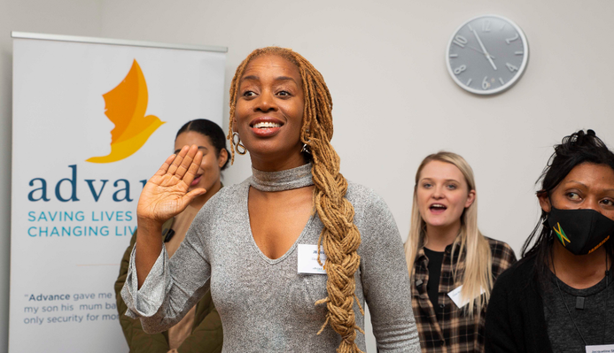 A photo of JB Rose at the opening of a new women's centre, delivering a signing workshop with Clean Break Members