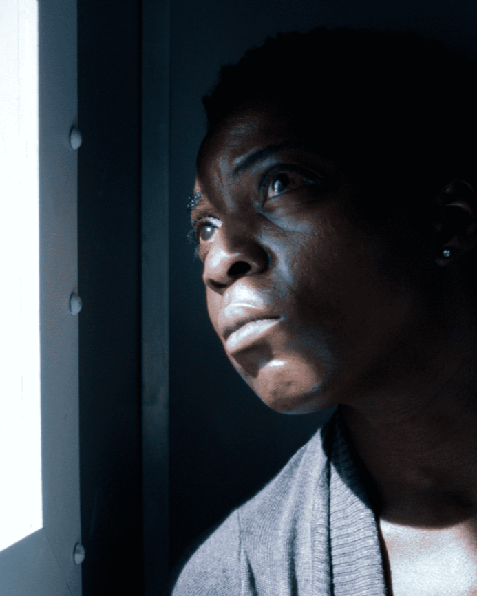 a woman looks out of the window of a prison van