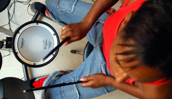 A photograph of a woman playing drums.