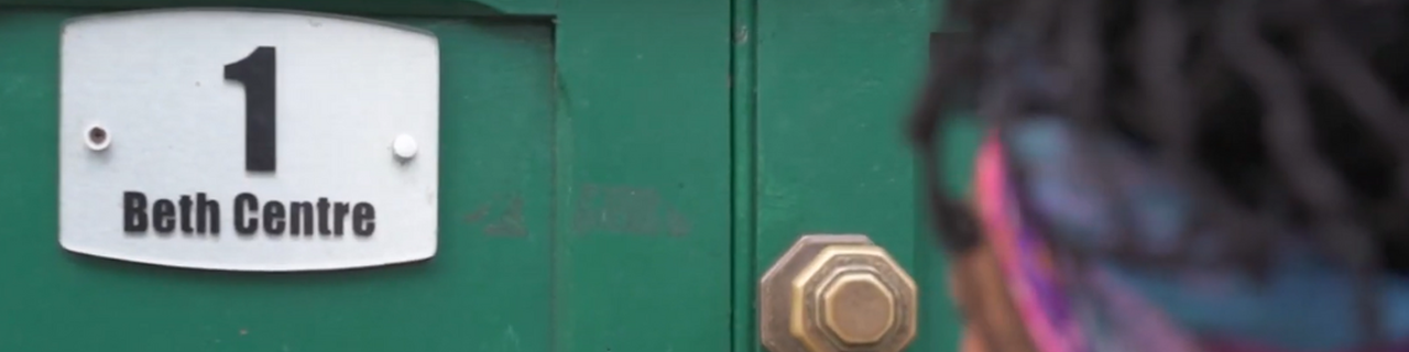 a woman walking up to a women's centre door