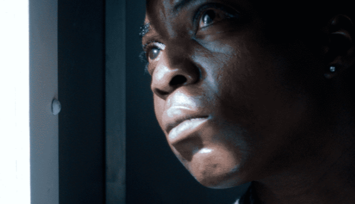 a woman looks out of the window of a prison van