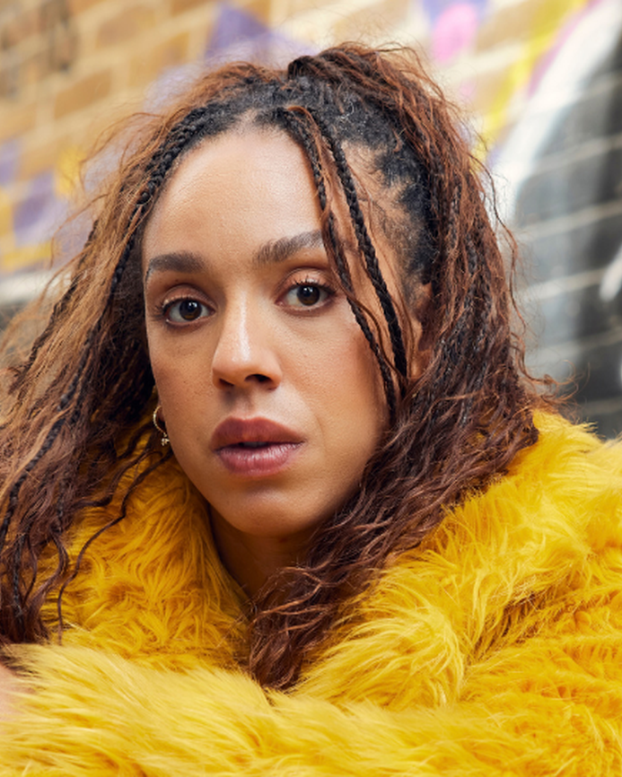 Pearl Mackie as Baby, wearing a yellow fur coat