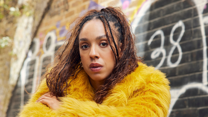Pearl Mackie as Baby, wearing a yellow fur coat