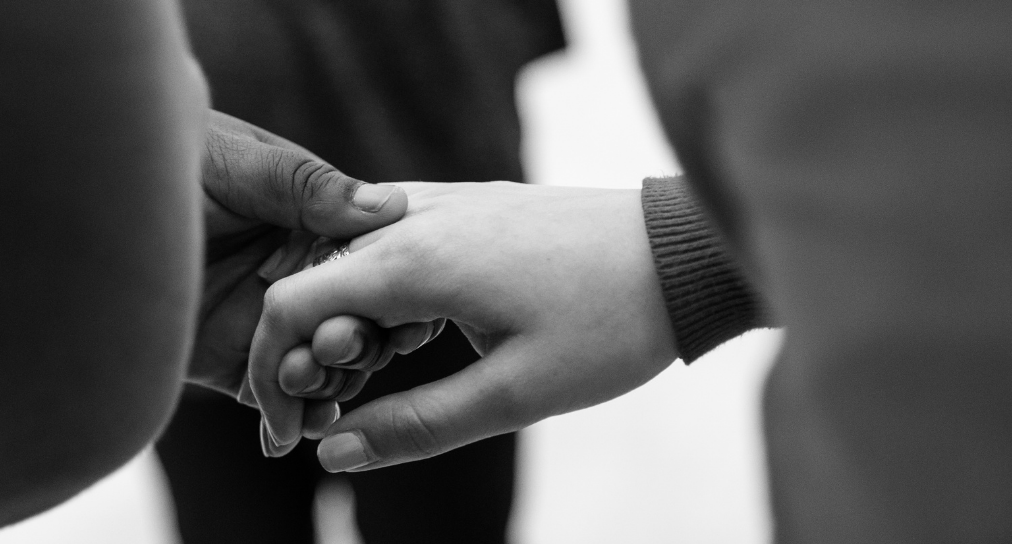 A black and white photo of two hands holding