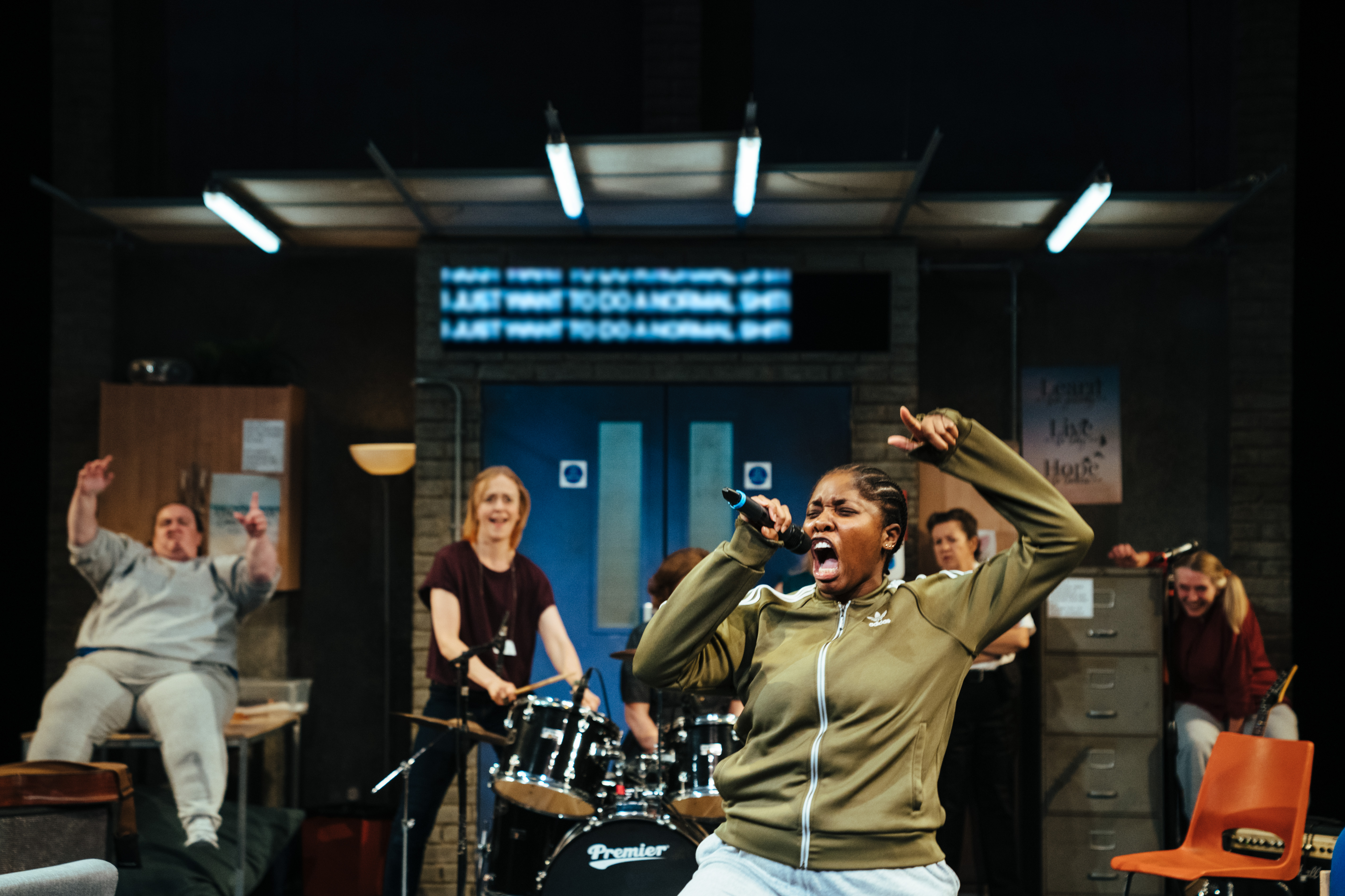 A photo of the cast of Typical Girls on stage performing as a band